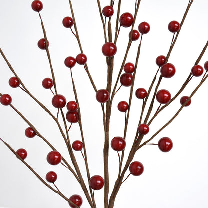 Close up of artificial red berry branches on a white background